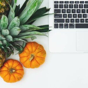 pumpkins and pineapple next to laptop
