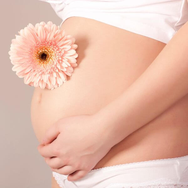 Fleur sur ventre de femme enceinte
