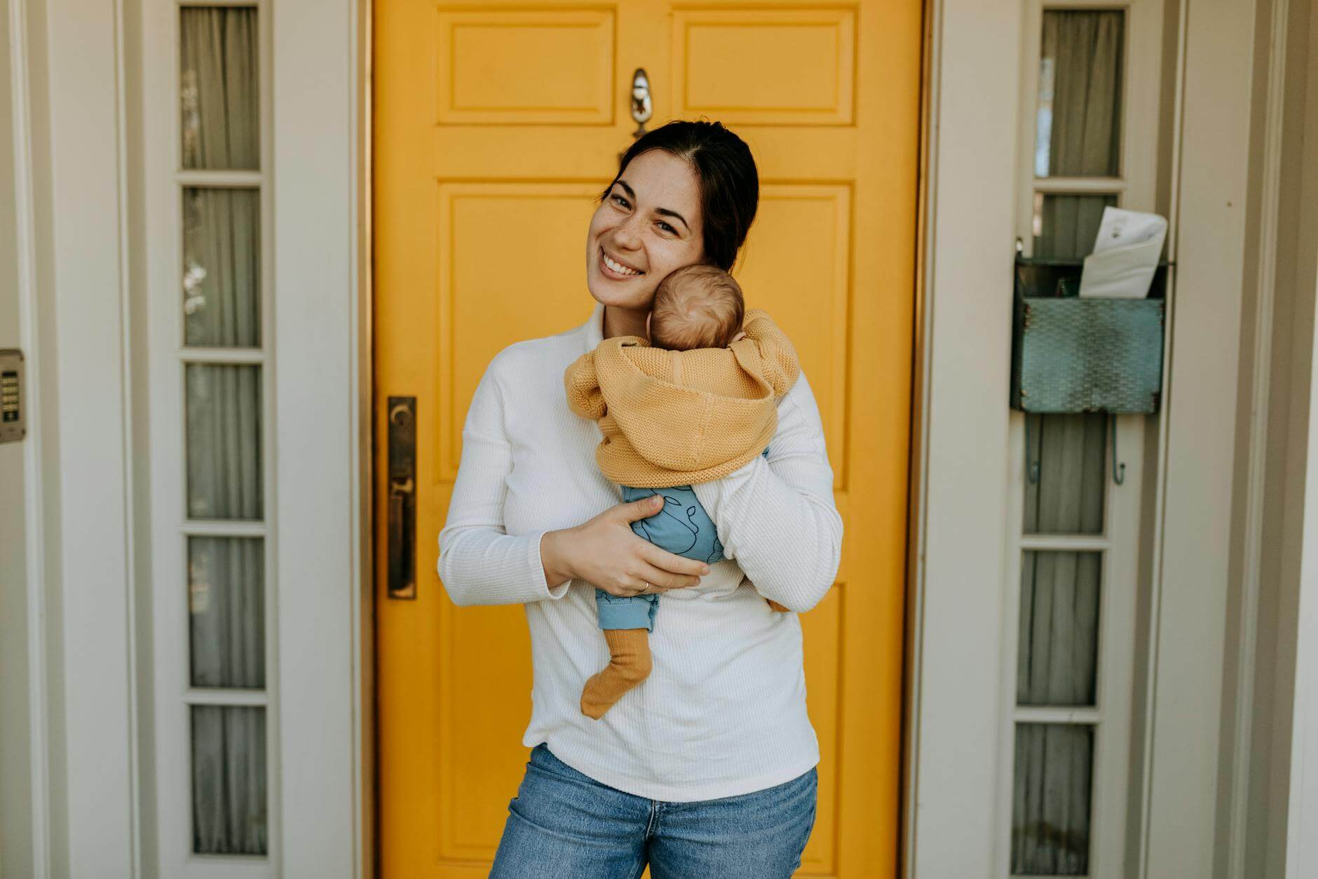 woman in white long sleeves holding her baby