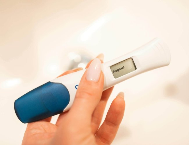 a woman hand holding a digital pregnancy test kit
