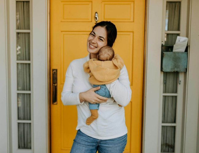 woman in white long sleeves holding her baby